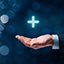 Ein Symbolbild Das Bild zeigt eine Hand, über der ein blau leuchtendes Kreuz schwebt.
